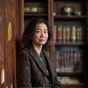民俗学研究者林晓燕的学术照，中年女性，学院派气质，背景为民俗文物陈列室